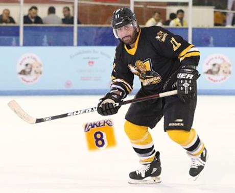 Greg Scott on the ice in a Q Beat tribute image featuring a Lakers number 8 jersey